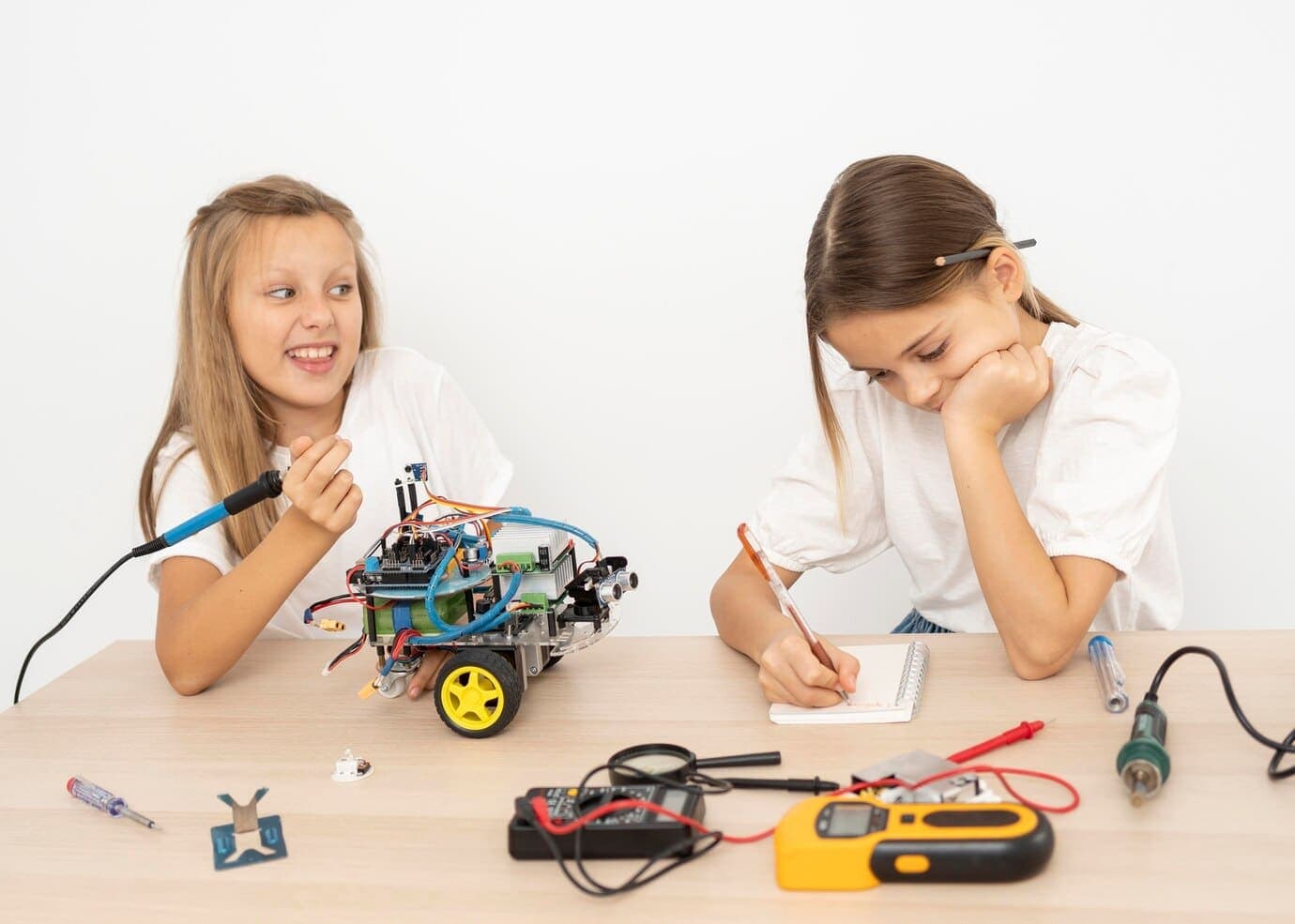 Two young people working together on a robotic car experiment